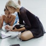 Impress Interviewers - Impressed Asian little ballerina with instructor using laptop