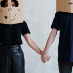 Creative Diy Fashion - A Couple Wearing Diy Cardboard Box Mask While Holding Each Other's Hands